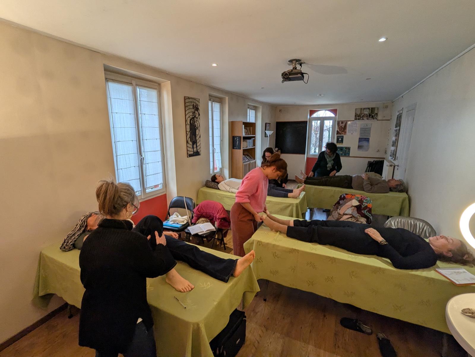 Élèves de l'Académie ETC en séance pratique de soins manuels sur table, pendant un week-end de formation